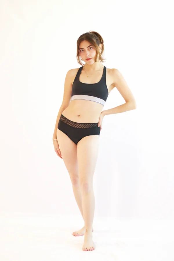 Modelo usando el Calzón Menstrual ASHA de Alella Flow, corte bikini de cintura baja para flujo ligero.